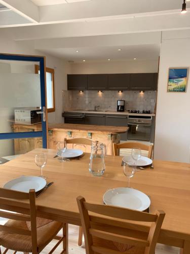 - une table en bois avec des verres à vin dans l'établissement Dépendance bord de mer, à Plozévet