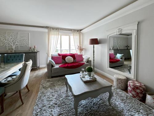 un salon avec un canapé, une table et un miroir dans l'établissement Le Danube 11 - Appartement luxe 8 personnes à Disneyland Paris, à Serris