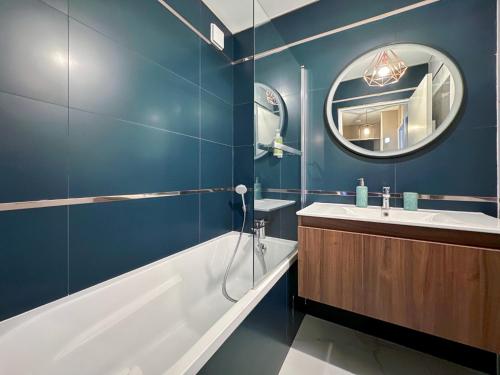 une salle de bain avec une baignoire, un lavabo et un miroir dans l'établissement Le Danube 11 - Appartement luxe 8 personnes à Disneyland Paris, à Serris