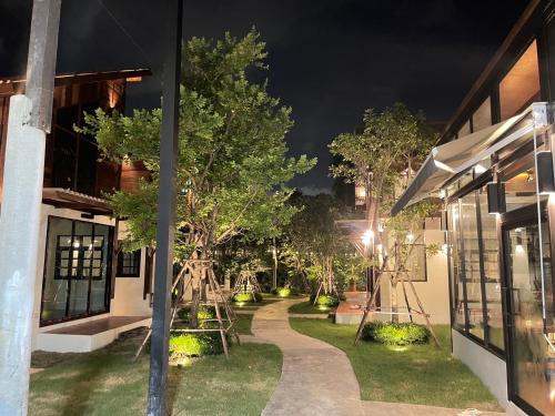 a night view of a garden with trees and swings at Baanrongmai Canal Front in Bang Chak