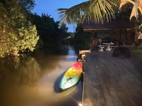 a kayak parked next to a house on a river at Baanrongmai Canal Front in Bang Chak