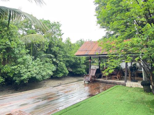 a house with a wooden deck with a gazebo at Baanrongmai Canal Front in Bang Chak