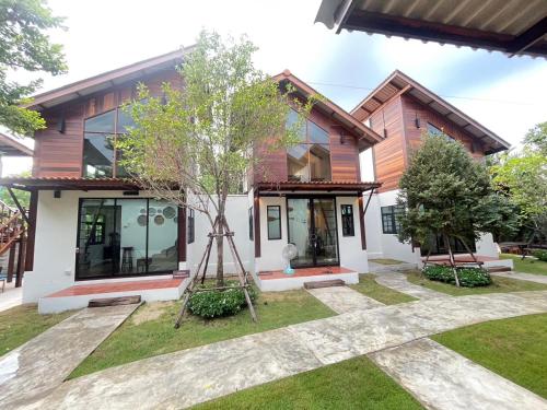 a house with a tree in front of it at Baanrongmai Canal Front in Bang Chak