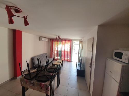 un salon avec une table et des chaises et une cuisine dans l'établissement Joli appartement St Cyprien Village, à Saint-Cyprien