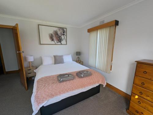 a bedroom with a bed with two bags on it at Devonport's Relax at Manning in Devonport