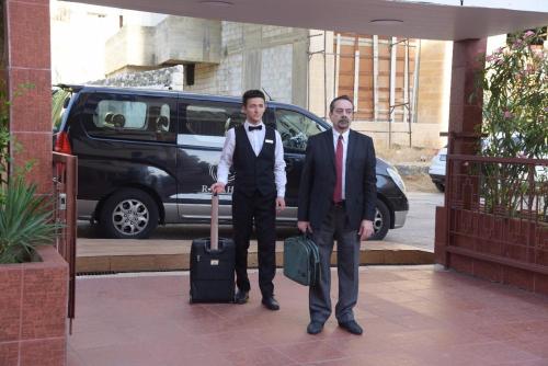 two men standing next to each other with a suitcase at Vanda Boutique Hotel & Spa By Rafahia in Jounieh