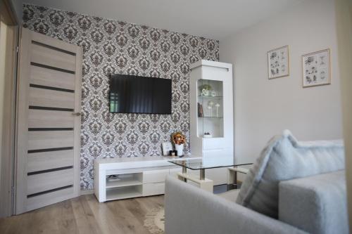 un soggiorno con un divano e una TV a parete di Butterfly apartment a Šiauliai