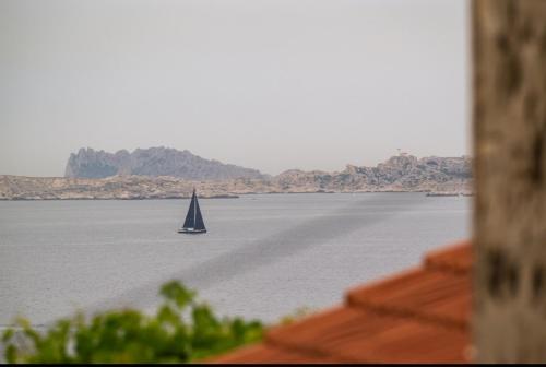 un voilier au milieu d'une grande étendue d'eau dans l'établissement Alt Niolon Maison, piscine vue mer et Marseille, à Le Rove