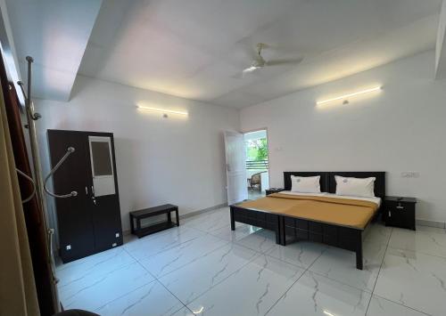 a bedroom with a bed in a white room at Avanthi Homestay in Varkala