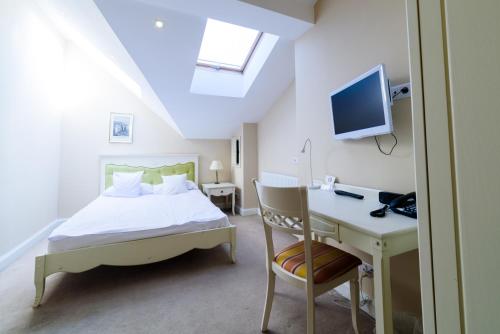 a bedroom with a bed and a desk with a computer at Ambasadorski Residence in Rzeszów