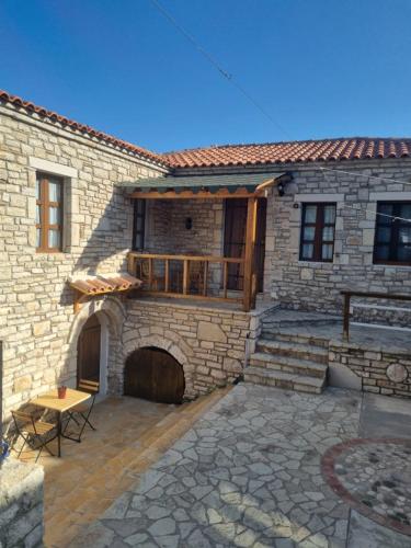 a stone house with a patio in front of it at Villa Olive Old Qeparo in Qeparo