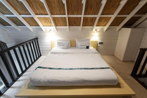 a bedroom with a large bed with white sheets and pillows at Tree House Relax Park in Chişinău