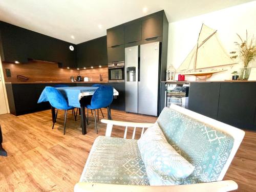 a kitchen and a living room with a couch and a table at jolie résidence proche du centre ville à Roscoff in Roscoff