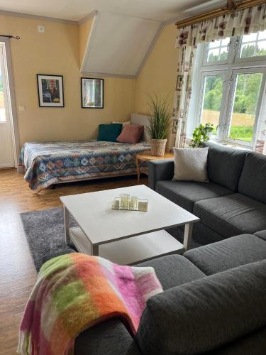 a living room with a couch and a coffee table at Rosa Huset Osebol in Stöllet