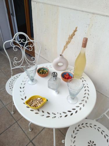 a white table with a bottle of wine and snacks at Private Room in Cozy Homestay - Line 14, Direct Access to Paris - Airport Orly in Chevilly-Larue