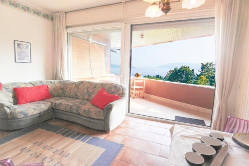 a living room with a couch and a large window at Selva Salvia in Cissano