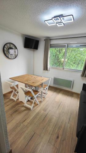 une salle à manger avec une table et des chaises en bois dans l'établissement Studio Avenue de la muzelle ménage et draps inclus proche Belle étoile et Esf, à Les Deux Alpes