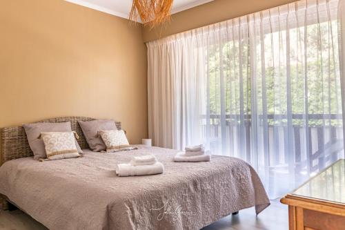 une chambre avec un lit et une grande fenêtre dans l'établissement Montfleuri, à Villeneuve-Loubet