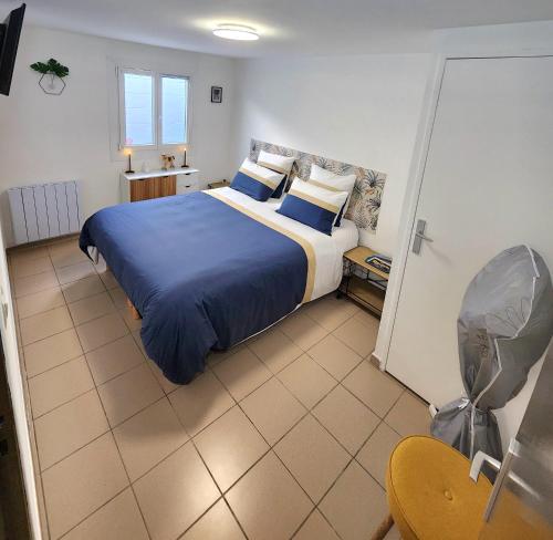 une chambre avec un grand lit avec des draps et des oreillers bleus dans l'établissement Gite De La Borre Becque, à Merville