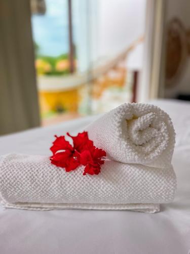 a towel with a red flower on a table at La Reserve Villa Tropicana in Pipa