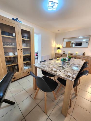 une cuisine avec une table et des chaises dans une pièce dans l'établissement Gite De La Borre Becque, à Merville