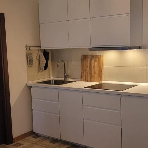 a kitchen with white cabinets and a sink at Casa Bettina in Pizzo