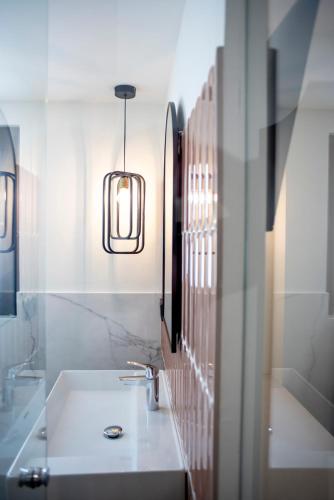 a bathroom with a sink and a pendant light at Citrea Santander in Santander