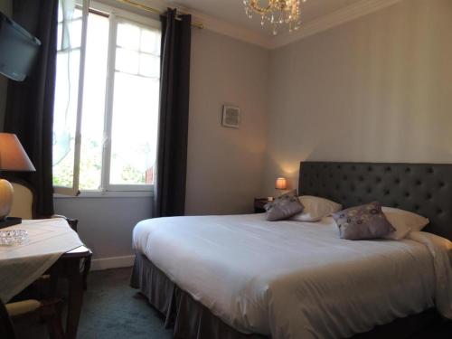 a bedroom with a bed with two pillows on it at La Villa Bois Joli HOTEL RESTAURANT in Bagnoles de l'Orne