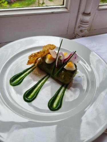 a white plate with food on a table at La Villa Bois Joli HOTEL RESTAURANT in Bagnoles de l'Orne