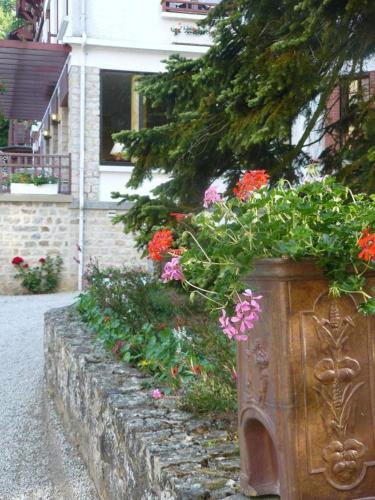 a planter filled with flowers in front of a building at La Villa Bois Joli HOTEL RESTAURANT in Bagnoles de l'Orne