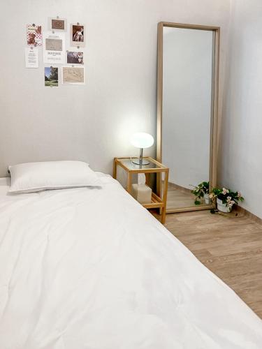 a bedroom with a white bed and a mirror at Sodam Haengoong in Suwon