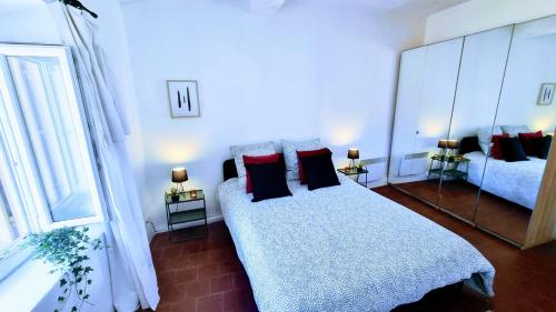 - une chambre avec un lit doté d'oreillers et d'un miroir dans l'établissement Le Portes à Coté des Halles Entièrement Rénové, à Sète