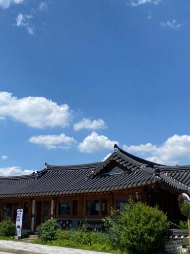 a building with a black roof with a sky at Sodam Haengoong in Suwon