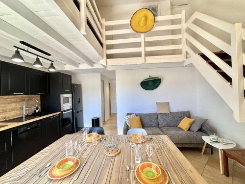 Il comprend une cuisine et un salon avec une table en bois. dans l'établissement Appartement 105 résidence Terra Bella 1 Porticcio, à Porticcio