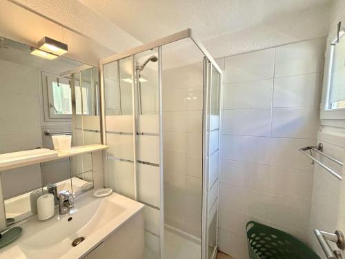 une salle de bain blanche avec une douche et un lavabo dans l'établissement Appartement 105 résidence Terra Bella 1 Porticcio, à Porticcio