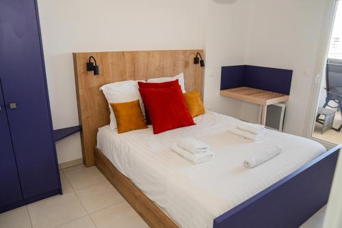 - une chambre avec un lit doté d'oreillers rouges et oranges dans l'établissement Sete Thau Indigo 403, à Sète