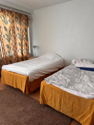 two beds sitting next to each other in a bedroom at Grand Hostel Imatra in Imatra