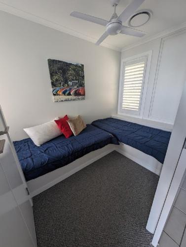 a bedroom with a blue couch in a room at Villa 36 Tangalooma in Tangalooma