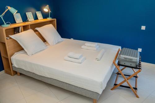 - une chambre avec un lit, des serviettes et une chaise dans l'établissement Sete, Apt 2 chambres, Terrasse et proximite plages, à Sète
