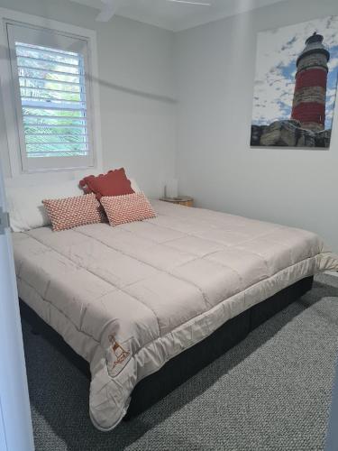a bed in a bedroom with a window and a lighthouse at Villa 36 Tangalooma in Tangalooma