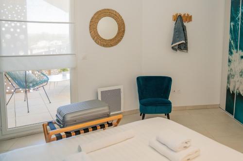 Cette chambre comprend un lit, une chaise et une fenêtre. dans l'établissement Sete, Apt 2 chambres, Terrasse et proximite plages, à Sète