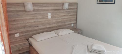 a bed with white sheets and pillows in a room at Homer Studio in Nydri