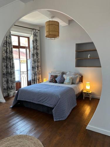 a bedroom with a large bed with an archway at L'enthousiasme in Prades