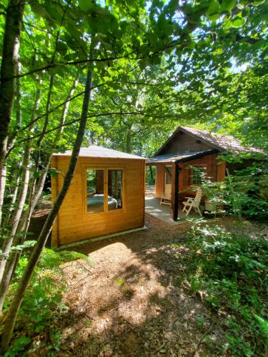 a small wooden cabin in the middle of a forest at Cabane des bois in Rouffignac Saint-Cernin