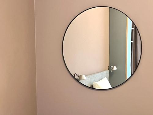 a mirror hanging on a wall in a bathroom at MY PLACE Hotel in Hamburg