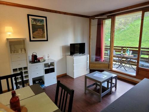 un salon avec une table et une salle à manger dans l'établissement Appartement Hauteurs Super Besse - 4 personnes -Piscine & Garage, à Besse-et-Saint-Anastaise