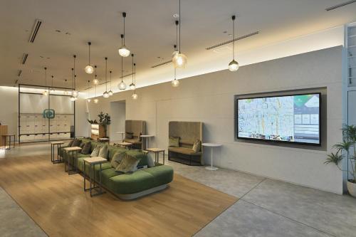 a living room with couches and a flat screen tv at Prince Smart Inn Osaka Yodoyabashi in Osaka