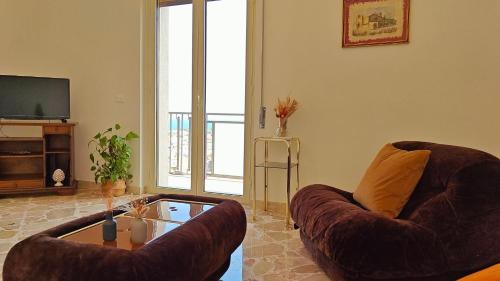 a living room with two chairs and a coffee table at Al Pianotto, appartamento vintage ad Avola, vista Mare in Avola
