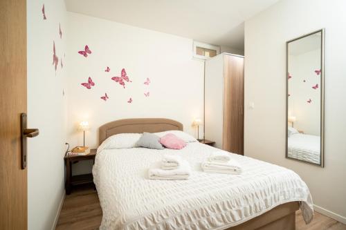 a bedroom with a bed with butterflies on the wall at Apartman Margareta in Matulji