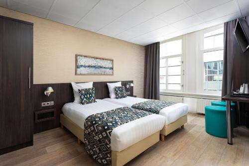 En eller flere senge i et værelse på Hotel Damsquare